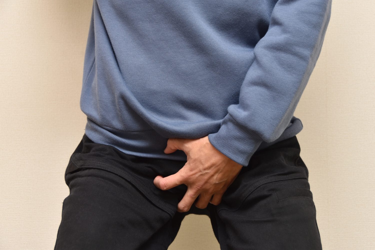引け腰で股間を押さえる男