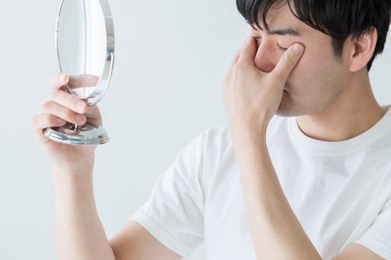 目を触る男性