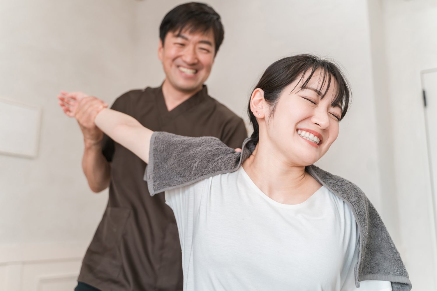 腕や肩のマッサージをする整体師と患者