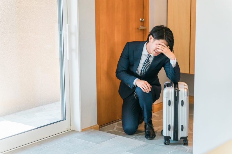 出張から帰宅した疲れた多忙なビジネスマン