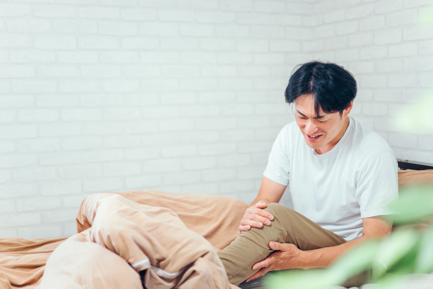 足をさわる男性