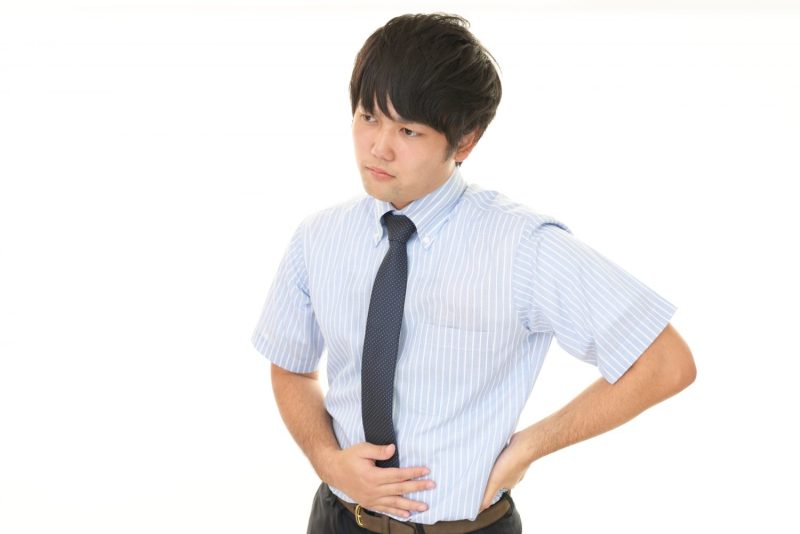 お腹を押さえる男性