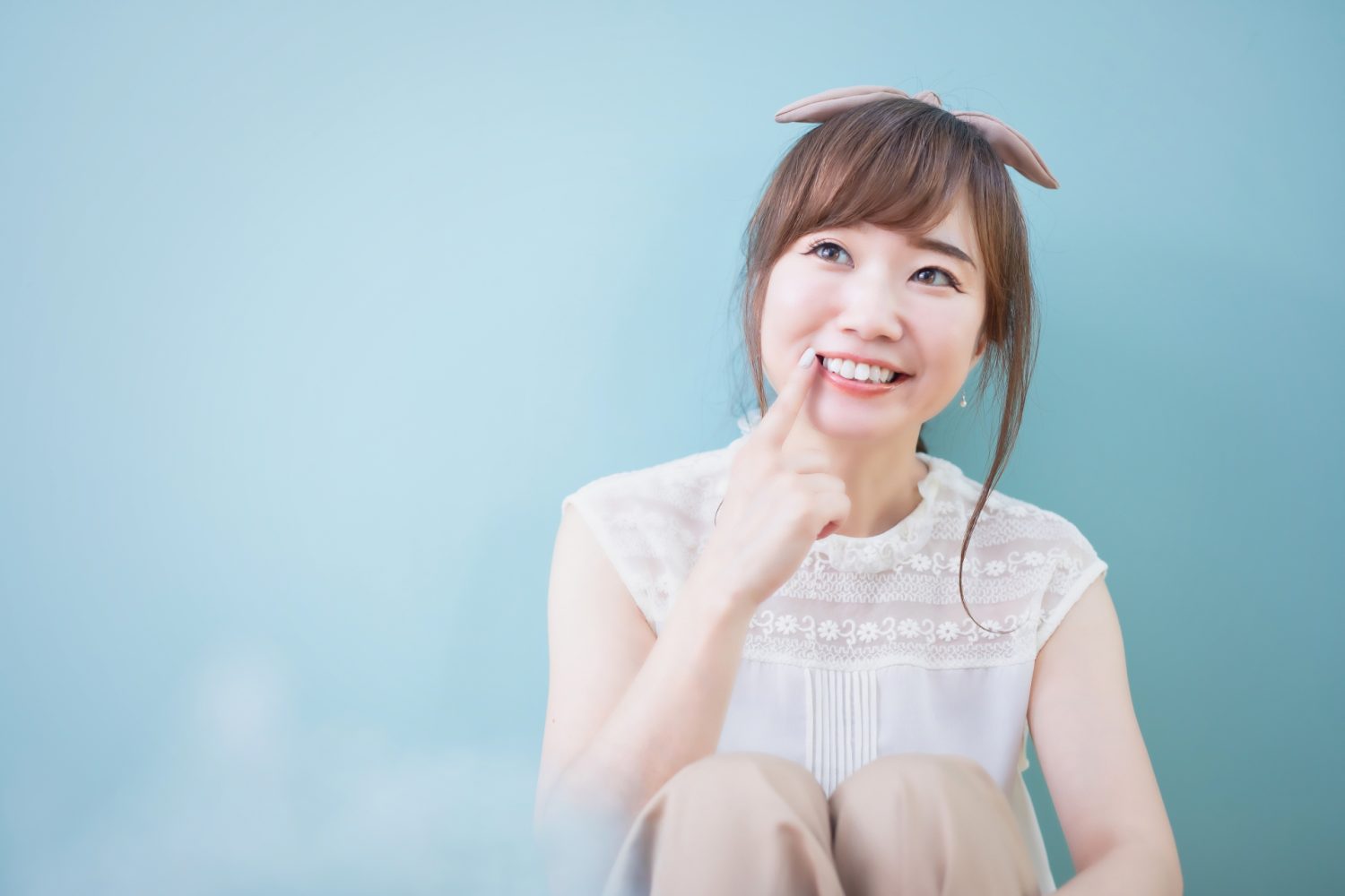 口元を指さす女性