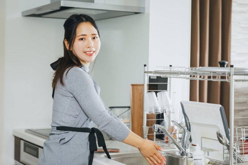 キッチンで手を洗う主婦