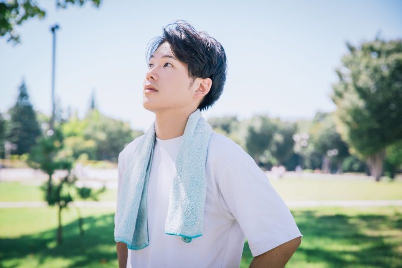 緑の中で爽やかに運動する男性