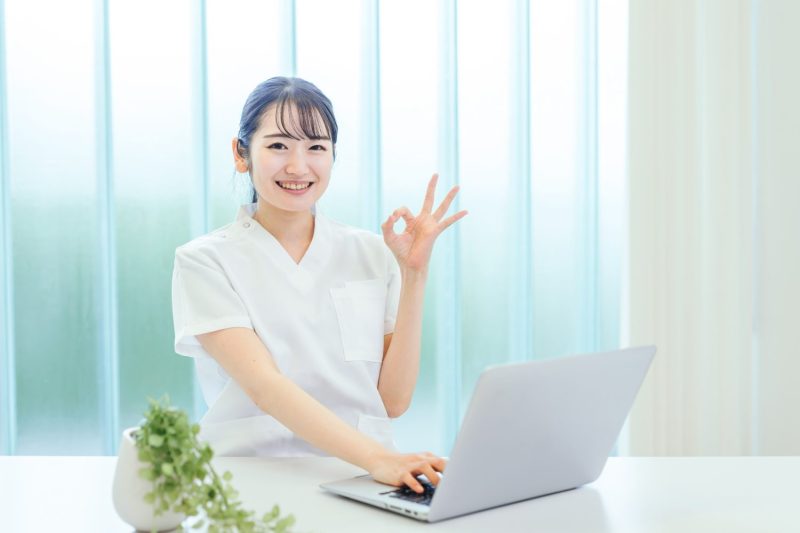 パソコンを使う白衣姿の女性