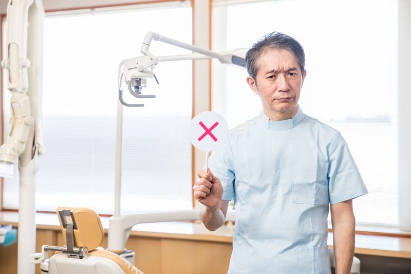 ばつ印と歯科医師