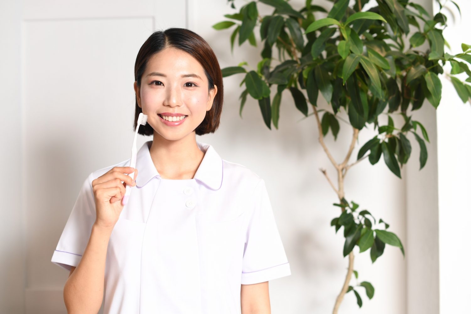 歯ブラシを持つ歯科医師の若いアジア人女性