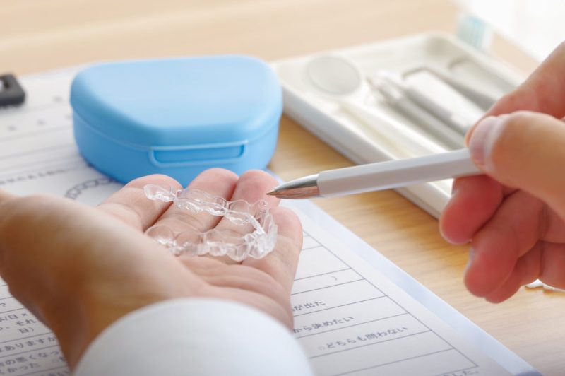 歯科医療のマウスピースの説明をする男性