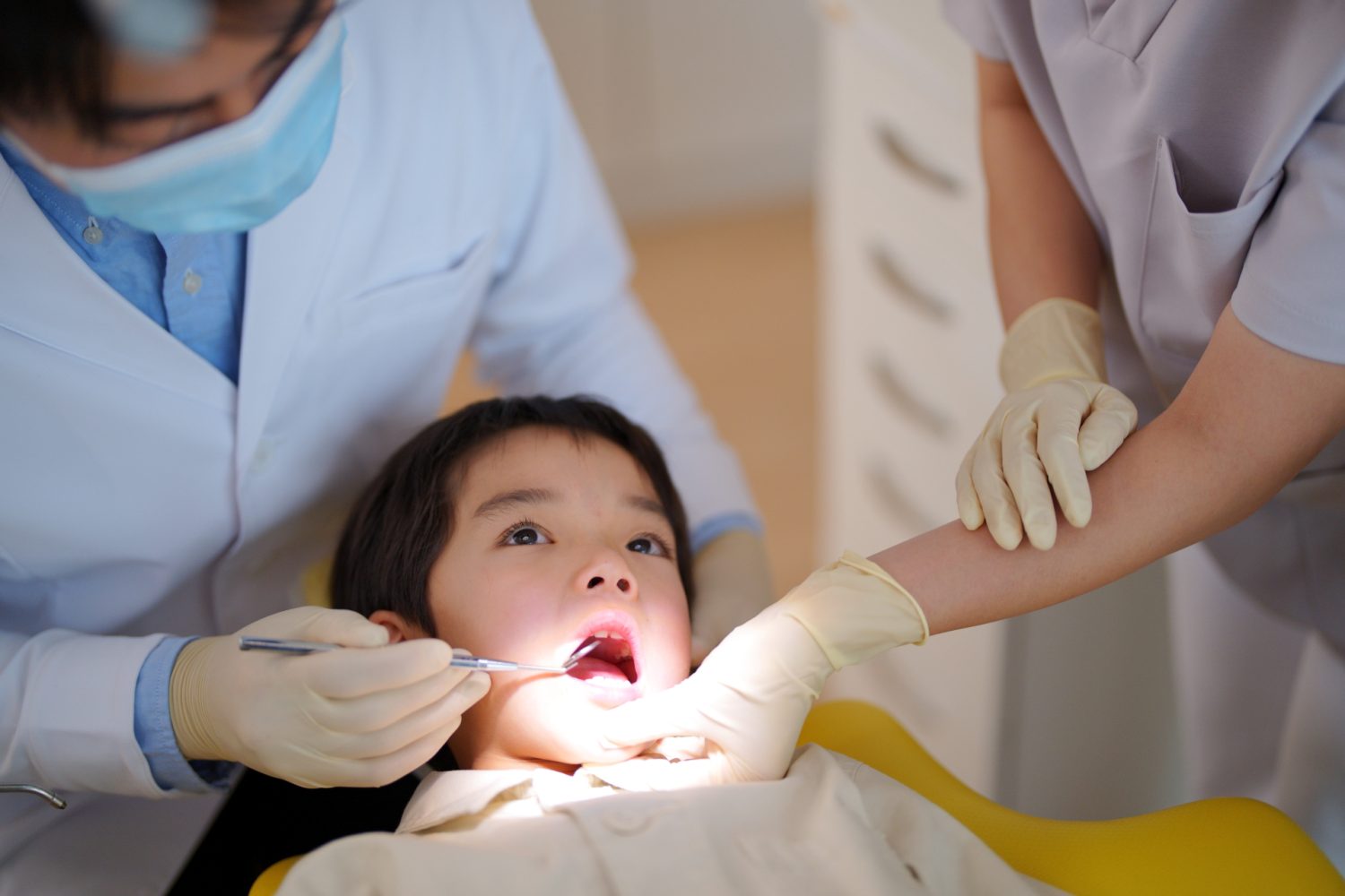 男の子の歯科検診と歯科衛生士の手元