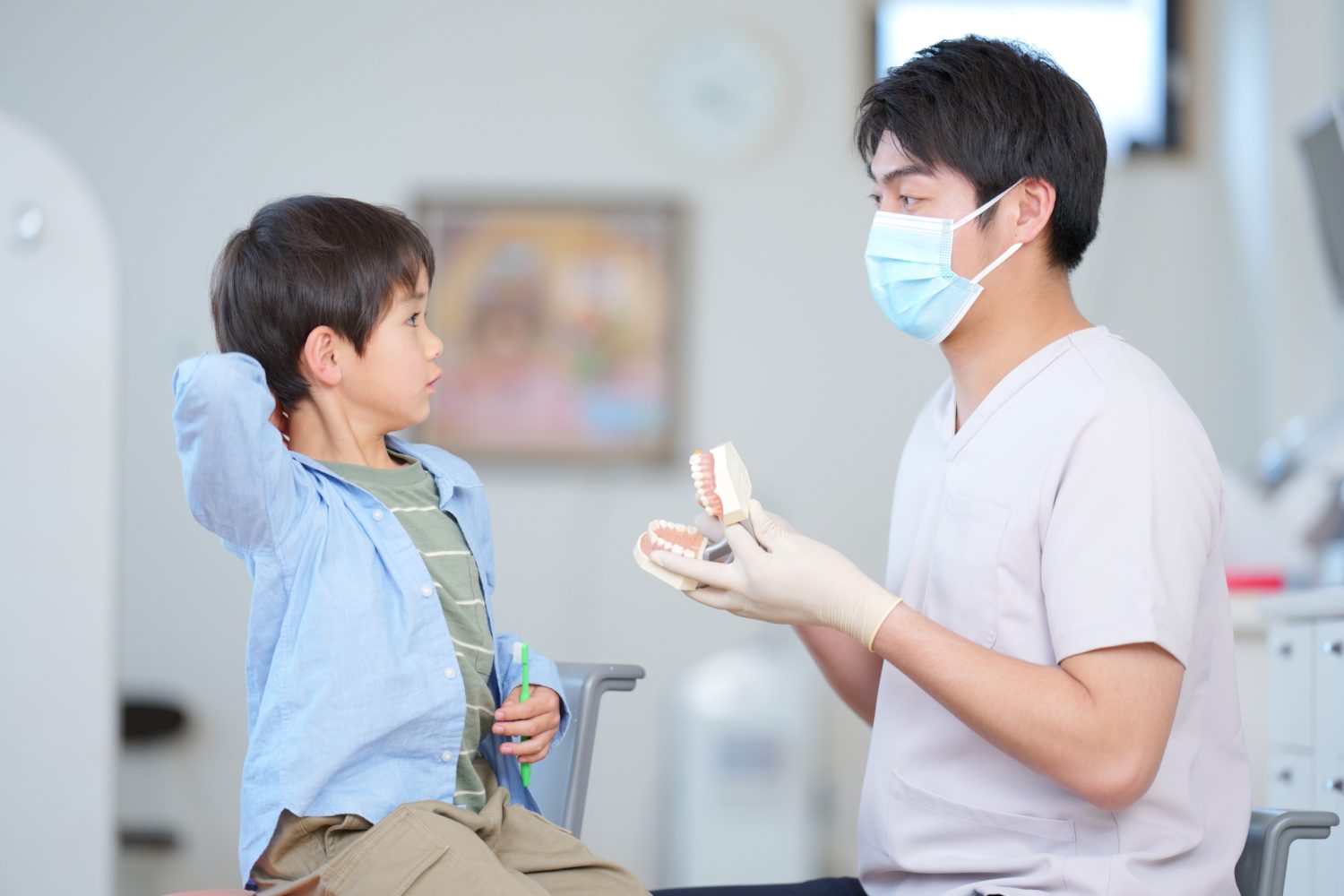 向かい合って見つめる男の子と歯科医の男性