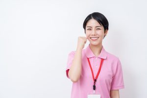 ガッツポーズをする介護士の女性。
