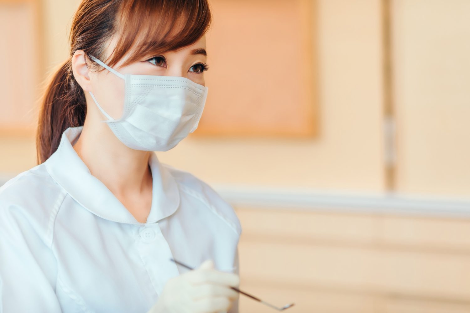 歯ブラシを持つ歯科医師の若いアジア人女性