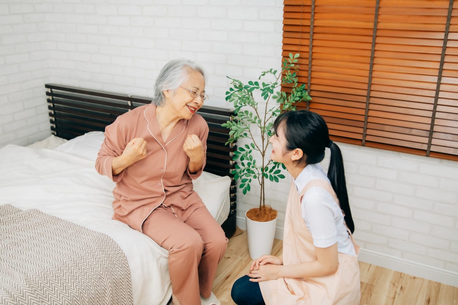 寝室にいる高齢者女性と介護する女性