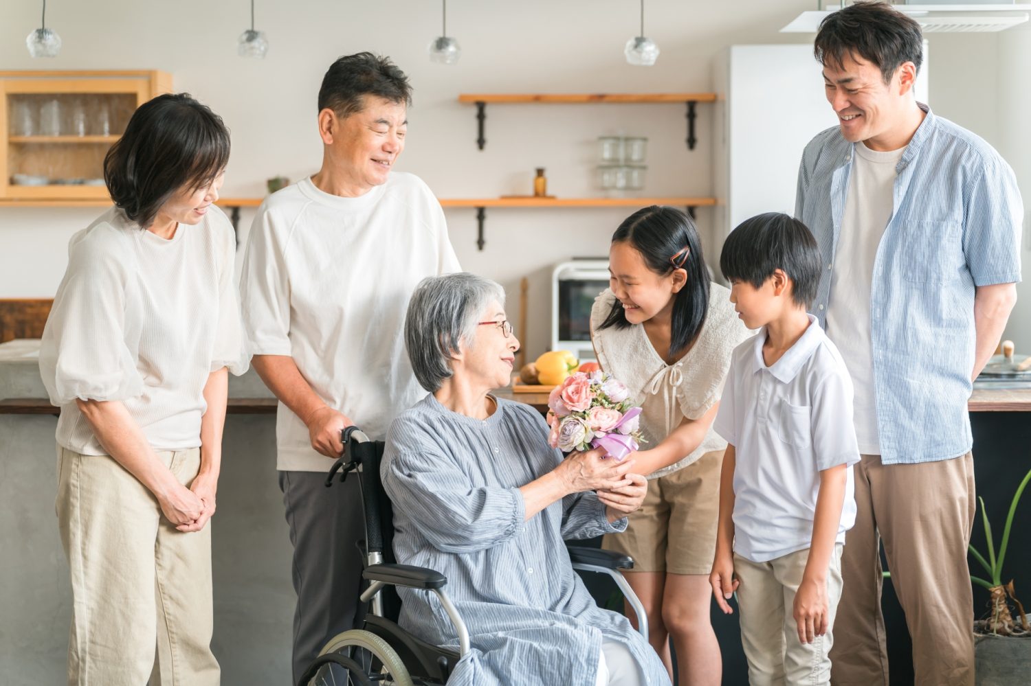 敬老の日・花束を持つ高齢者女性と家族