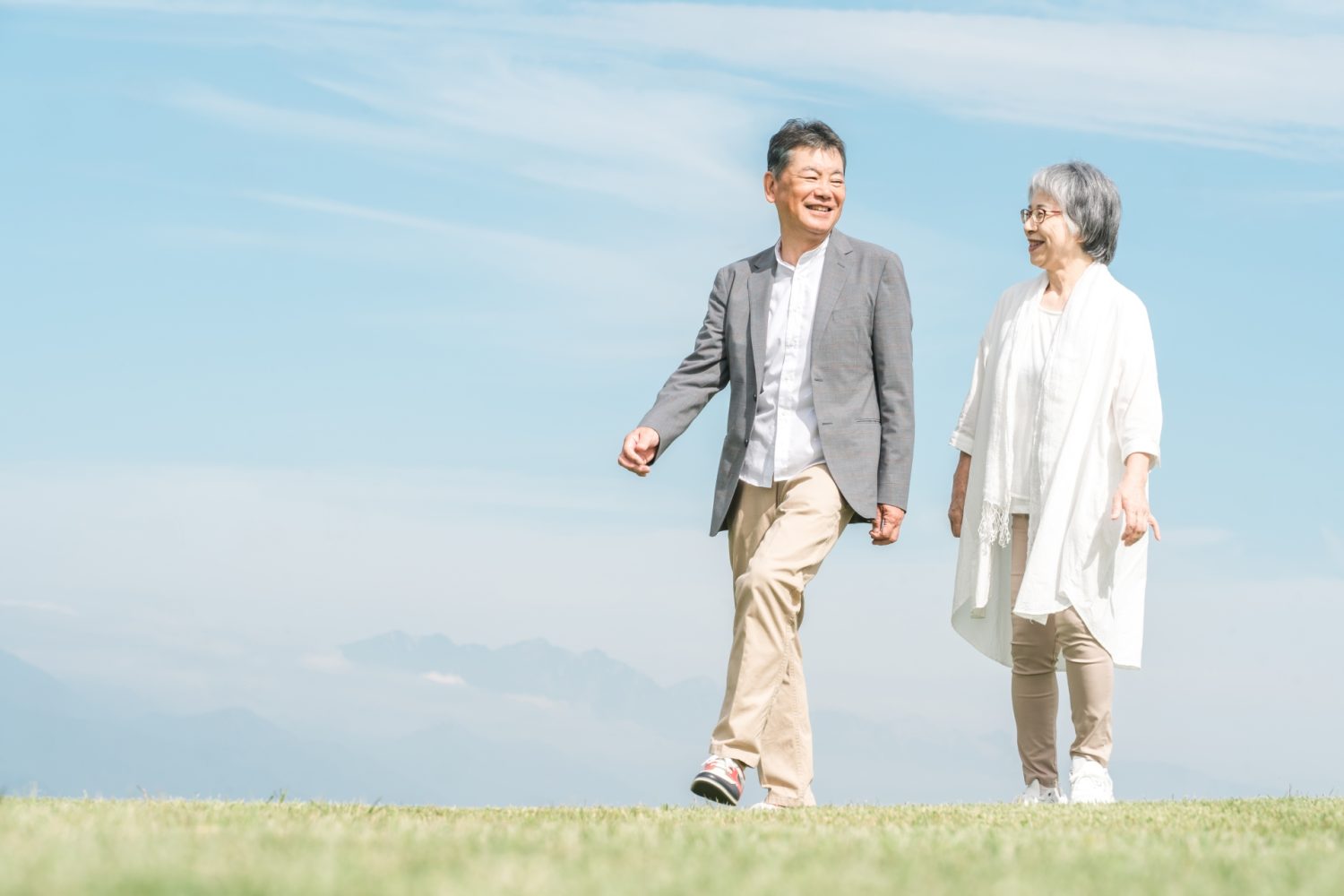 公園・旅行先を話しながら歩く高齢者夫婦