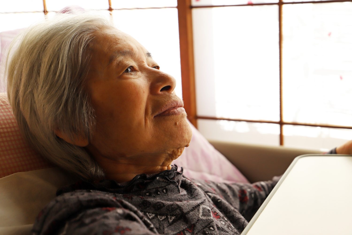 介護ベッドに横たわるシニア女性